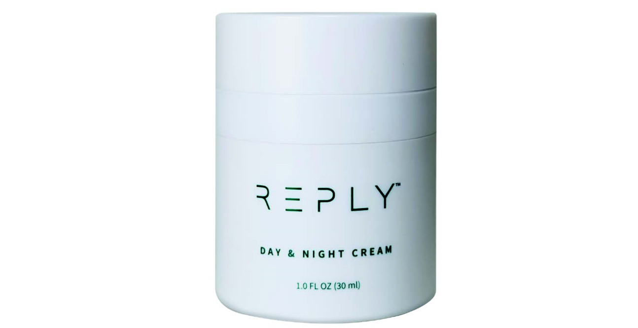 White jar of AIM REPLY Day & Night Cream on a white background