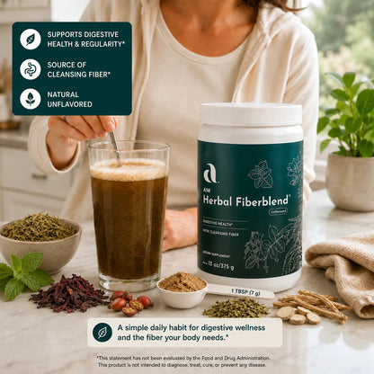 A person in a white top stands at a kitchen counter stirring a glass of AIM Herbal Fiberblend. The scene includes a dark green informational badge on the left, loose herbal ingredients, a small bowl of powder, and a folded beige cloth on the counter.